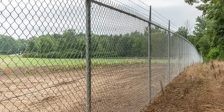 Tall chain link security fence around a commercial yard