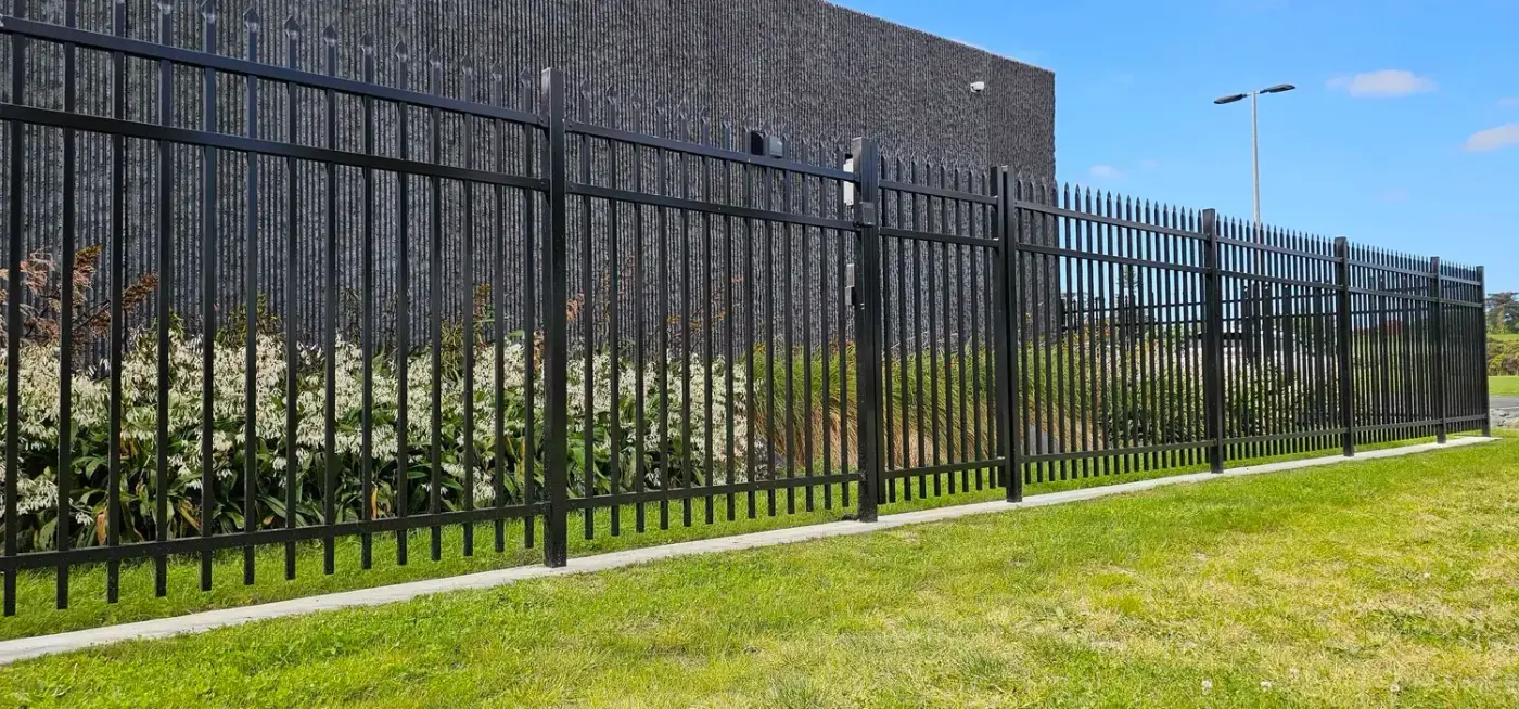 Black ornamental metal fence at a commercial entrance